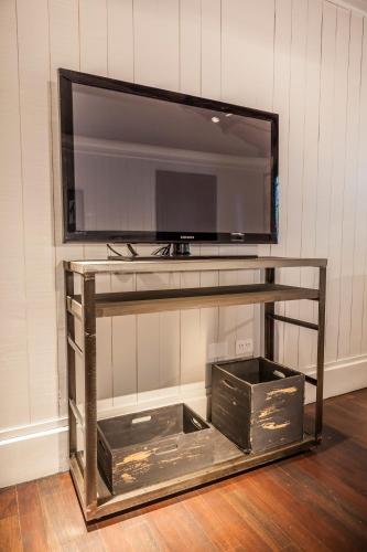 a entertainment center with a television on a wall at La Alondra, Casa de huéspedes in Corrientes