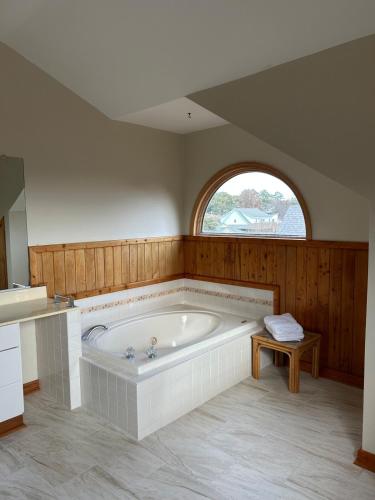 a large bath tub in a room with a window at Canal Front Boater's Paradise in Kill Devil Hills