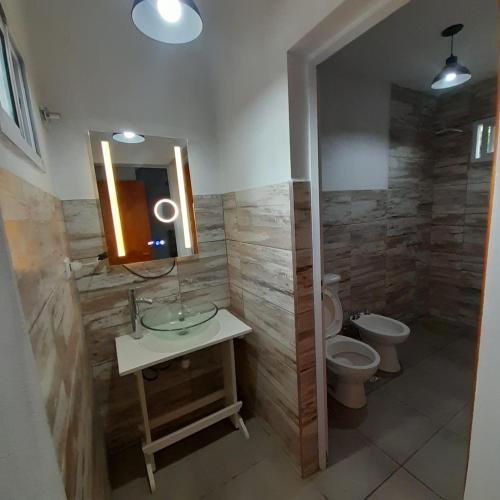 a bathroom with a sink and a toilet and a mirror at Complejo Lua in Villa Cura Brochero