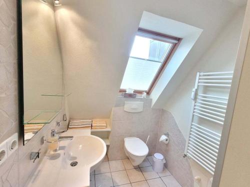 a bathroom with a sink and a toilet and a window at Holiday apartment in Wyk with swimming pool in Wyk auf Föhr
