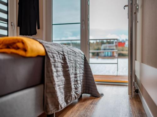 a blanket on a couch in a room with a window at Hausboot am See in Klitten