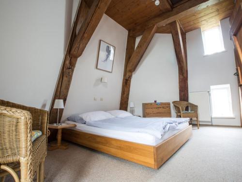 a bedroom with a large bed in a attic at Holiday home Mühle Catharina in Oldenswort