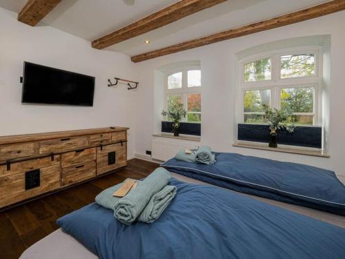 a bedroom with two beds and a flat screen tv at 1-bedroom apartment in Tating