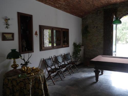 a room with chairs and a table and a piano at U Palazzu Corte in Corte
