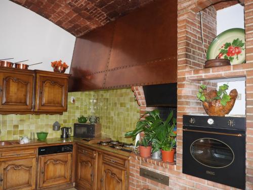 a kitchen with a stove top oven next to a brick wall at U Palazzu Corte in Corte