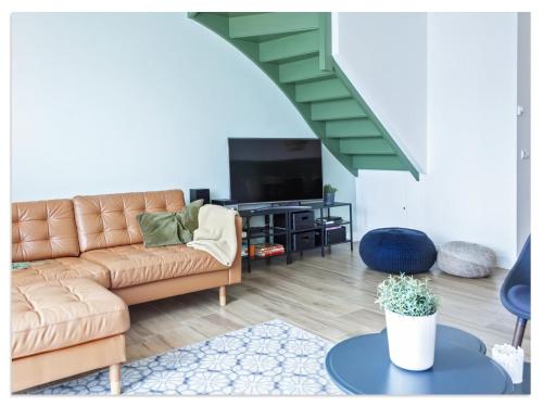 a living room with a couch and a tv at Waterfront Holiday Home with Terrace Views in Stavoren