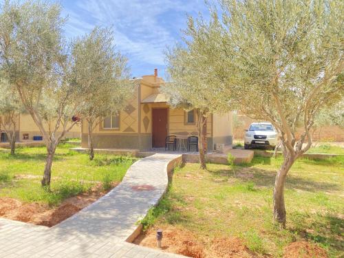a yellow house with trees in front of it at IGHIZ INN resort in Er Rachidia