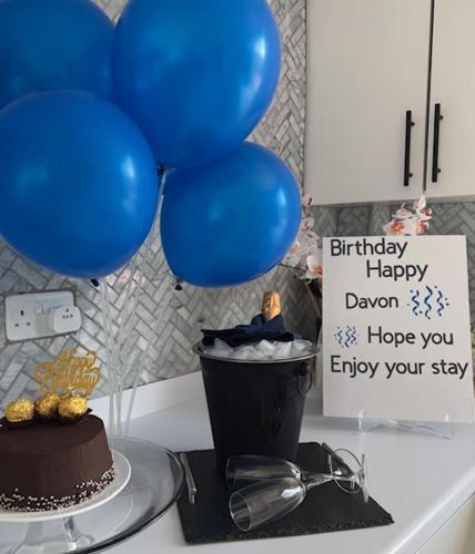 a table with a cake and balloons and a sign at Moulin A Vent Apartment in Monchy