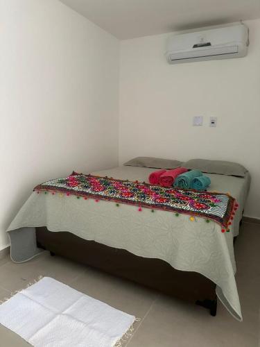 Bett mit einer Decke auf dem Zimmer in der Unterkunft Suíte Mar - Vila dos Pescadores Condomínio Portogalo in Angra dos Reis