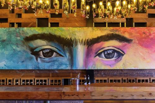 a painting of a woman with eyes on it at Casa Frida in Valle de Guadalupe
