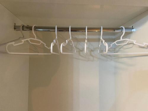 a shower curtain rod with hangers in a bathroom at Monte Carmel in Ribeirão Preto