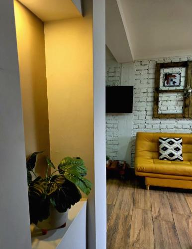 a living room with a yellow couch and a table at Cómodo Apartamento a 20 metros del parque in Salento