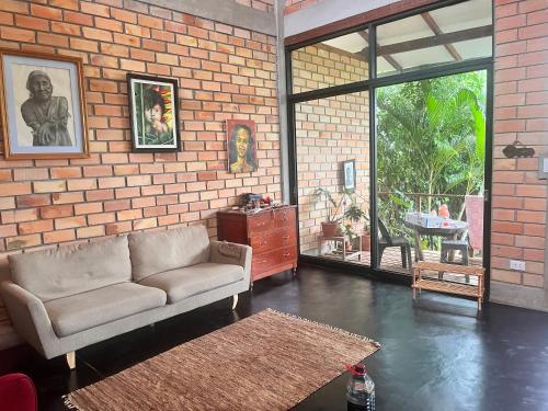 un soggiorno con un divano e un muro di mattoni di El Mirador de la Villa a Tarapoto