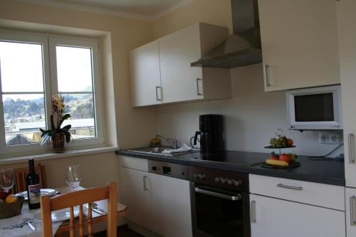 a kitchen with a sink and a stove top oven at Hotel Gasthof Schweizerhaus in Stuhlfelden
