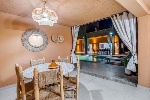 a dining room with a table and chairs and a mirror at Villa Lina 4 Chambres a Marrakech in Marrakech