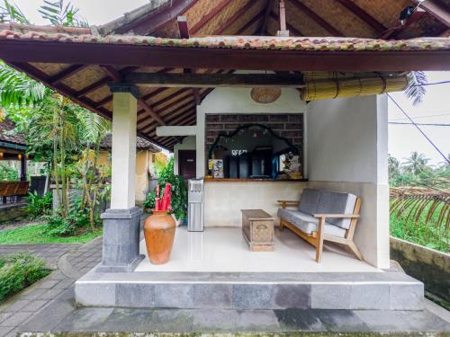 a patio of a house with a couch and a table at Ubud Shanti Rice Field House By Supala in Ubud