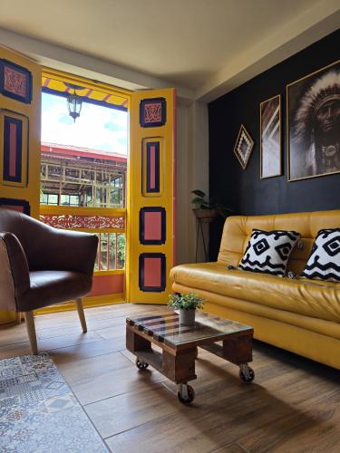 a living room with a yellow couch and a table at Confortable Apartamento a 20 mt del Parque Principal in Salento