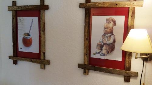 two framed pictures of a dog on a wall with a lamp at Estancia Renacimiento in Atlántida