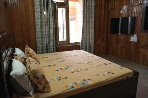 a large bed in a room with a television at city centre luxury villa in Jammu