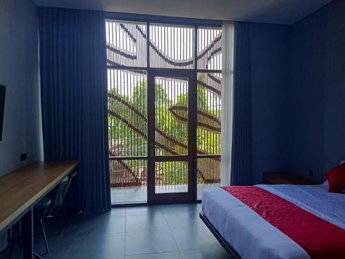 a bedroom with a bed and a large window at n&d guest house in Canggu