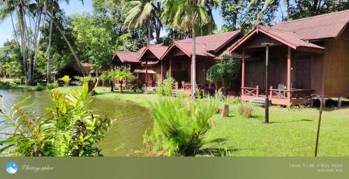 a resort building with a pond in front of it at Tanjung Inn in Kuantan