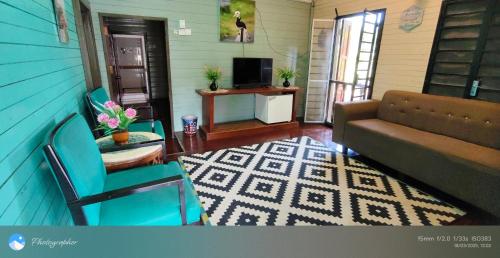 a living room with a couch and a tv at Tanjung Inn in Kuantan