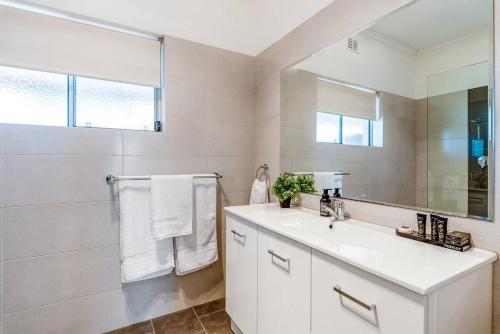 a white bathroom with a sink and a mirror at McGill Vineyard Barossa in Lights Pass