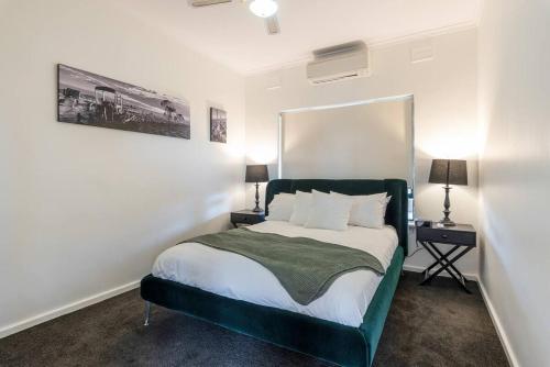 a bedroom with a bed with a green headboard at McGill Vineyard Barossa in Lights Pass