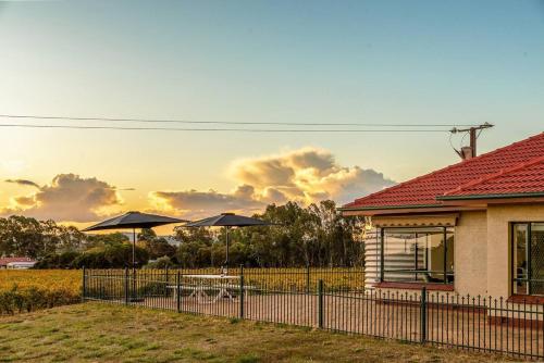 a house with two umbrellas in a yard at McGill Vineyard Barossa in Lights Pass