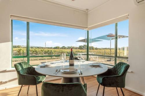 a dining room with a table and chairs and a large window at McGill Vineyard Barossa in Lights Pass