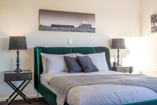 a bed with a green headboard in a bedroom at McGill Vineyard Barossa in Lights Pass