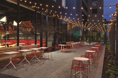 a row of tables and chairs outside of a building with lights at Radisson Red Minneapolis Downtown in Minneapolis
