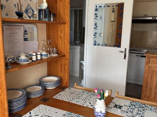 une cuisine avec une table et une porte dans l'établissement Charmant 2 pièces avec loggia à deux pas de la plage, parking, tout équipé - FR-1-712-38, à Villers-sur-Mer