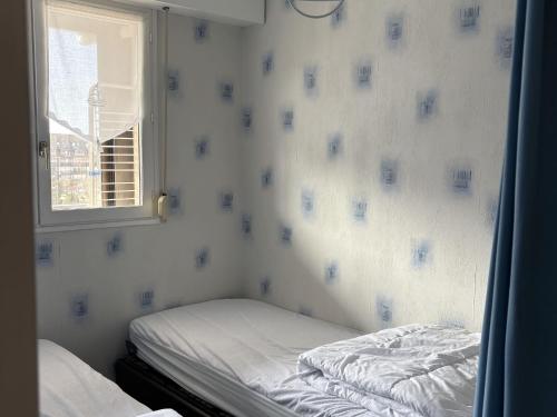 une petite pièce avec un lit et une fenêtre dans l'établissement Charmant 2 pièces avec loggia à deux pas de la plage, parking, tout équipé - FR-1-712-38, à Villers-sur-Mer