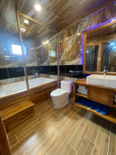 a bathroom with a tub and a toilet and a sink at KND Wind Valley Bình Thuận in Xóm Chum Găng