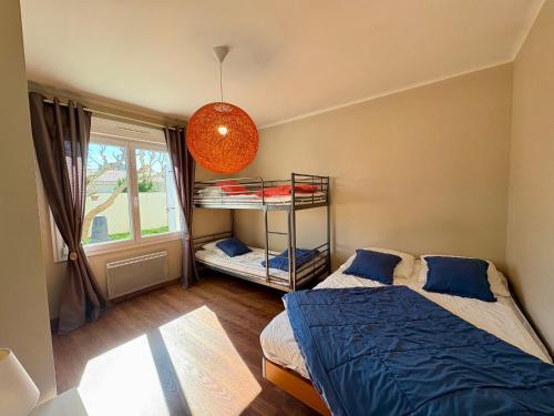 ein Schlafzimmer mit zwei Betten und einem Etagenbett in der Unterkunft Spacieuse Maison avec Piscine Privée - Cœur de Saint Jean de Monts - FR-1-323-381 in Saint-Jean-de-Monts