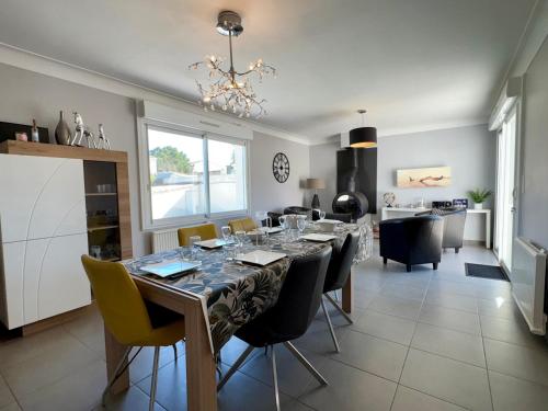 une salle à manger et une cuisine avec une table et des chaises dans l'établissement Maison Spacieuse avec Piscine Privée, Proche Centre et Plage, Saint Jean de Monts - FR-1-323-381, à Saint-Jean-de-Monts