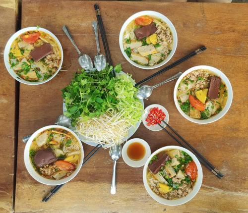 een groep kommen eten op een houten tafel bij KND Wind Valley Bình Thuận in Xóm Chum Găng