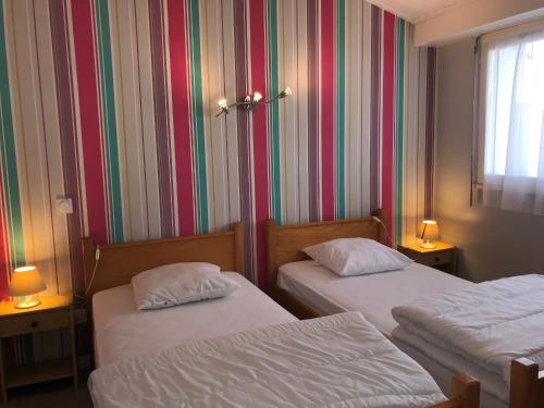 Cette chambre comprend 2 lits et un mur rayé. dans l'établissement Maison à Saint-Hilaire-de-Riez à proximité de la plage, 3 chambres, terrasse - FR-1-323-564, à Saint-Hilaire-de-Riez