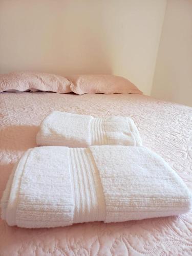 two white towels sitting on top of a bed at Suíte 1 - Vila dos Pescadores in Angra dos Reis