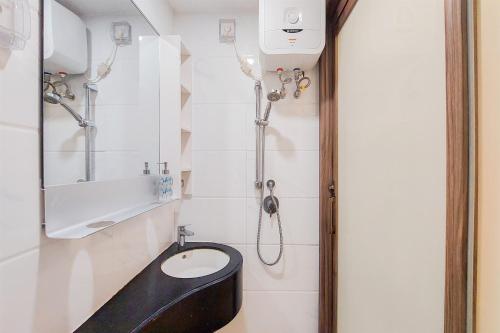 a bathroom with a black toilet and a sink at Comfy Designed and Modern Studio at Sky House BSD Apartment By Travelio in Tangerang