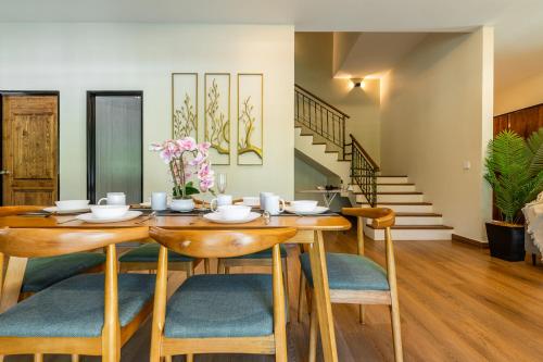a dining room with a wooden table and chairs at La Ferringhi Villa - Tropical Collection, by ALV in Batu Ferringhi