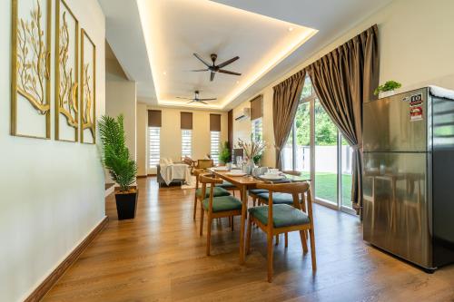 a dining room with a table and a refrigerator at La Ferringhi Villa - Tropical Collection, by ALV in Batu Ferringhi