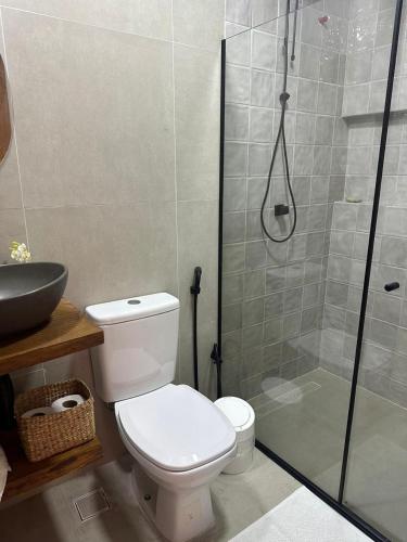 a bathroom with a toilet and a glass shower at Suíte 1 - Vila dos Pescadores in Angra dos Reis