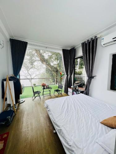 a bedroom with a bed and a table with chairs at Tram Homestay - Venuestay in Tam Ðảo