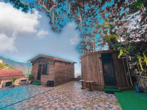 a small wooden cabin with a tree in the background at Tram Homestay - Venuestay in Tam Ðảo