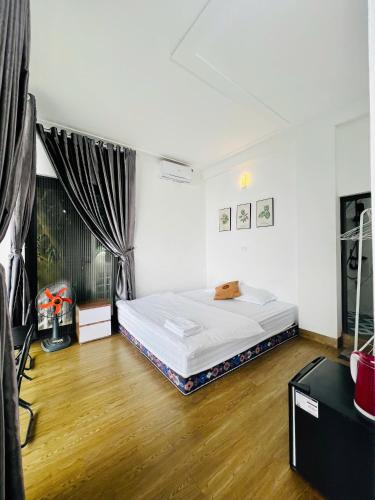 a bedroom with a bed and a wooden floor at Tram Homestay - Venuestay in Tam Ðảo