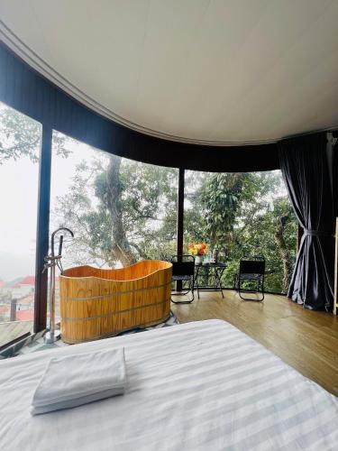 a bedroom with a bed and a large window at Tram Homestay - Venuestay in Tam Ðảo