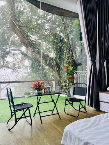 a room with a table and chairs and a large window at Tram Homestay - Venuestay in Tam Ðảo