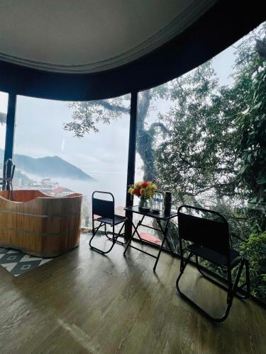 a room with a table and chairs and a large window at Tram Homestay - Venuestay in Tam Ðảo